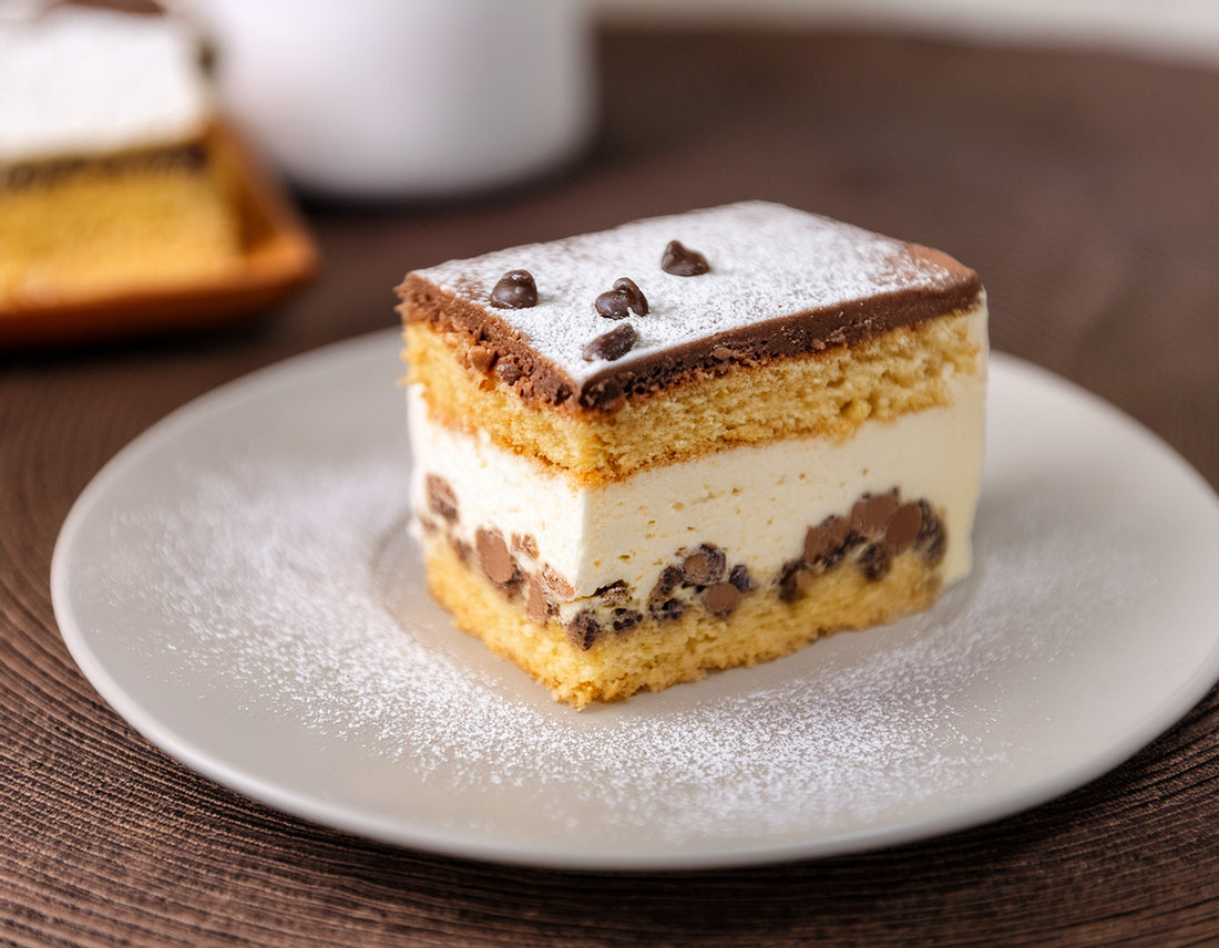 Slice of cannoli cake with ricotta mascarpone frosting and mini chocolate chips on a white plate