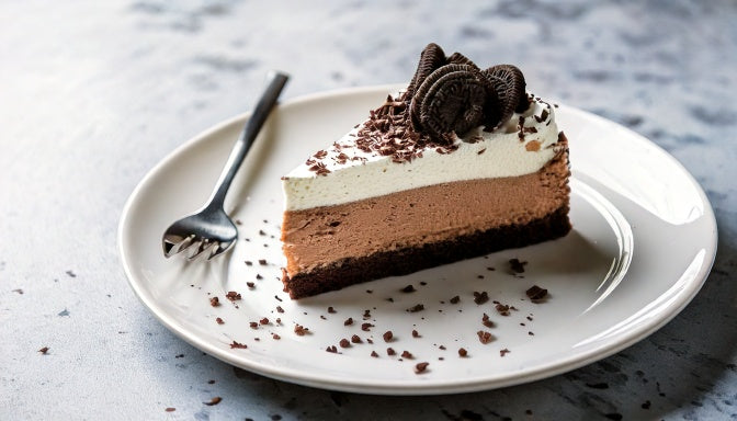 Slice of Oreo cheesecake with cookie crust and whipped cream, made to order and delivered across Los Angeles by Sweet Angeles