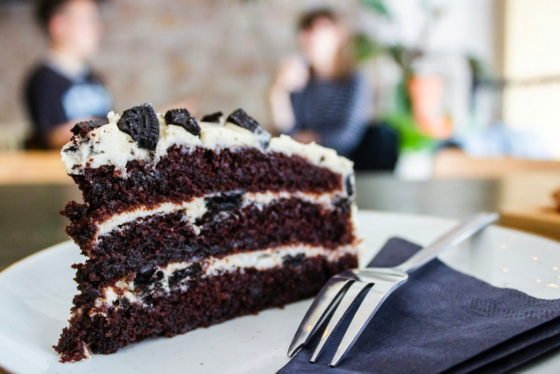 A slice of frosted vegan cake plated at a bakery