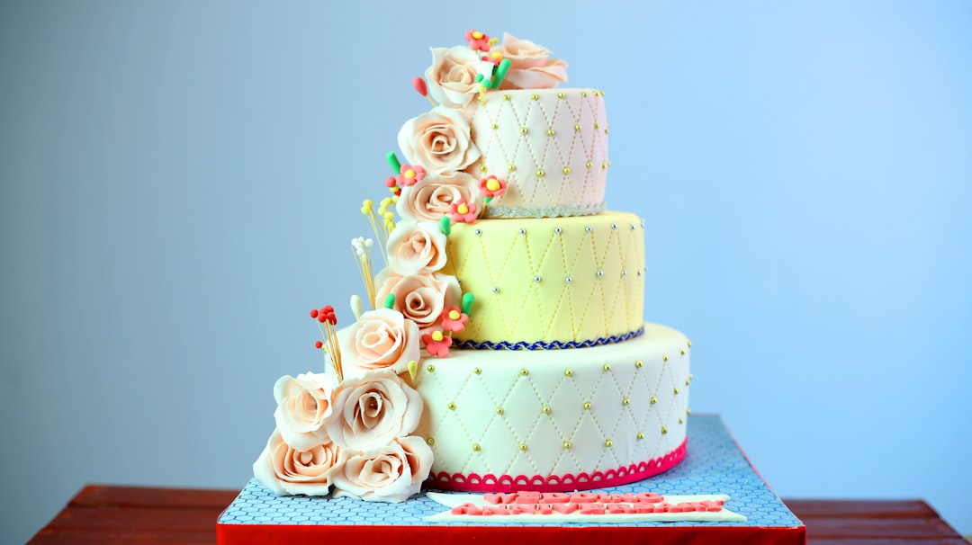 A tiered celebration cake with white and brown icing, the kind of clean base design used for a custom bar mitzvah or bat mitzvah cake