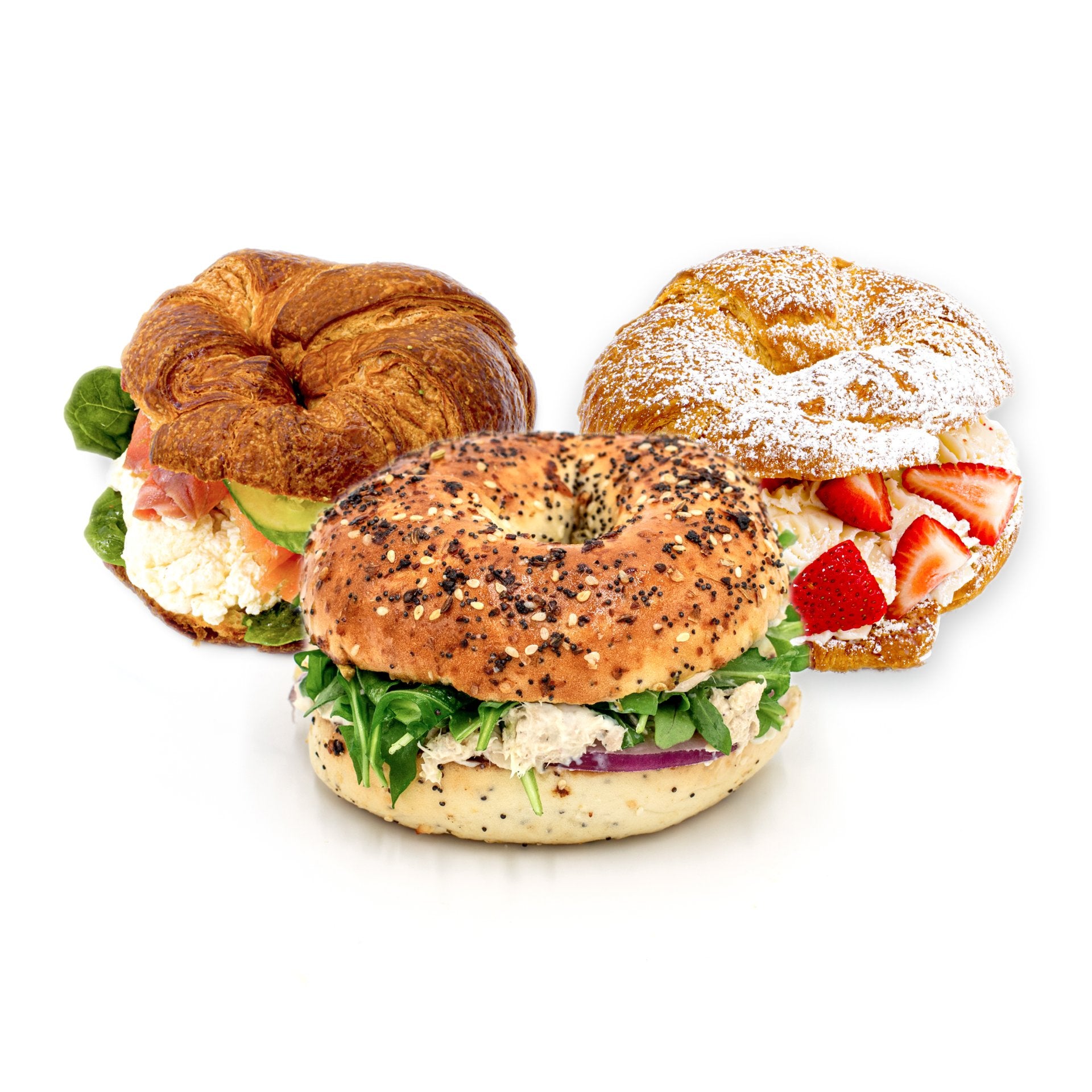Three sandwiches on different breads: a croissant with greens and cheese, a croissant with cream and strawberries dusted with powdered sugar, and an everything bagel with greens and chicken salad.
