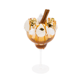 Gourmet ice cream sundae in glass with caramel drizzle, meringue, cinnamon sticks, and gold leaf