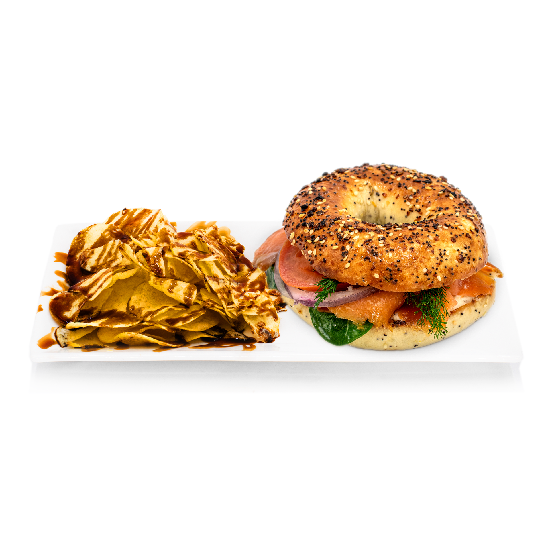 Everything bagel sandwich with smoked salmon, fresh greens, and chips drizzled with sauce on a plate