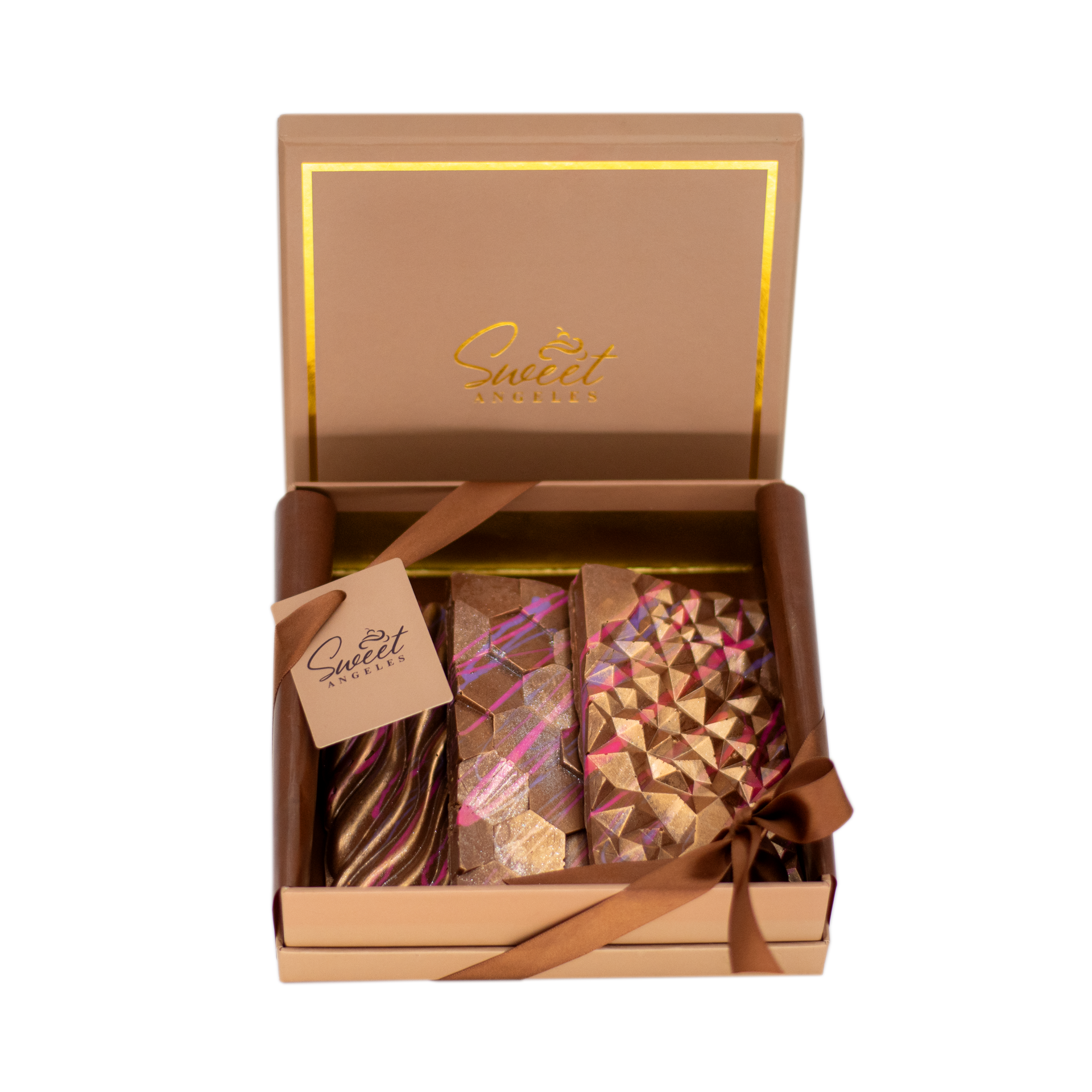 Box of geometric artisan chocolate bars with gold and pink designs, ribbon wrapped