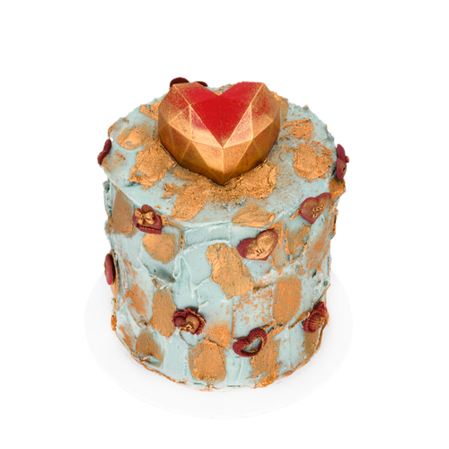 Custom blue frosted cake with gold accents and a geometric heart topper, gourmet dessert