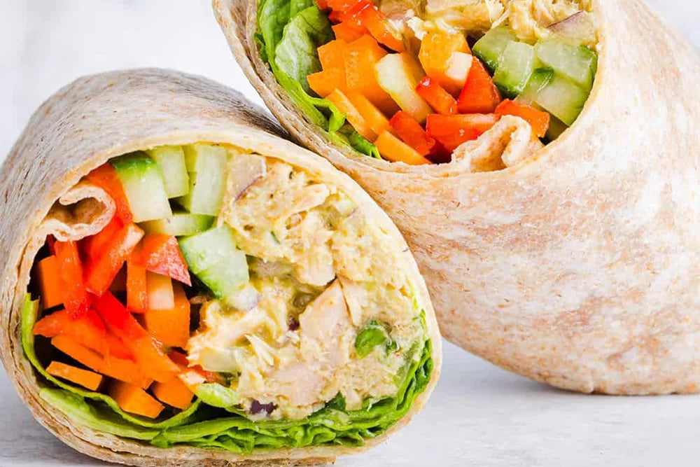 Fresh veggie and chicken wrap with lettuce, carrots, cucumbers, and bell peppers