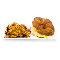 Croissant breakfast sandwich with egg and cheese served with chips drizzled in sauce on a plate