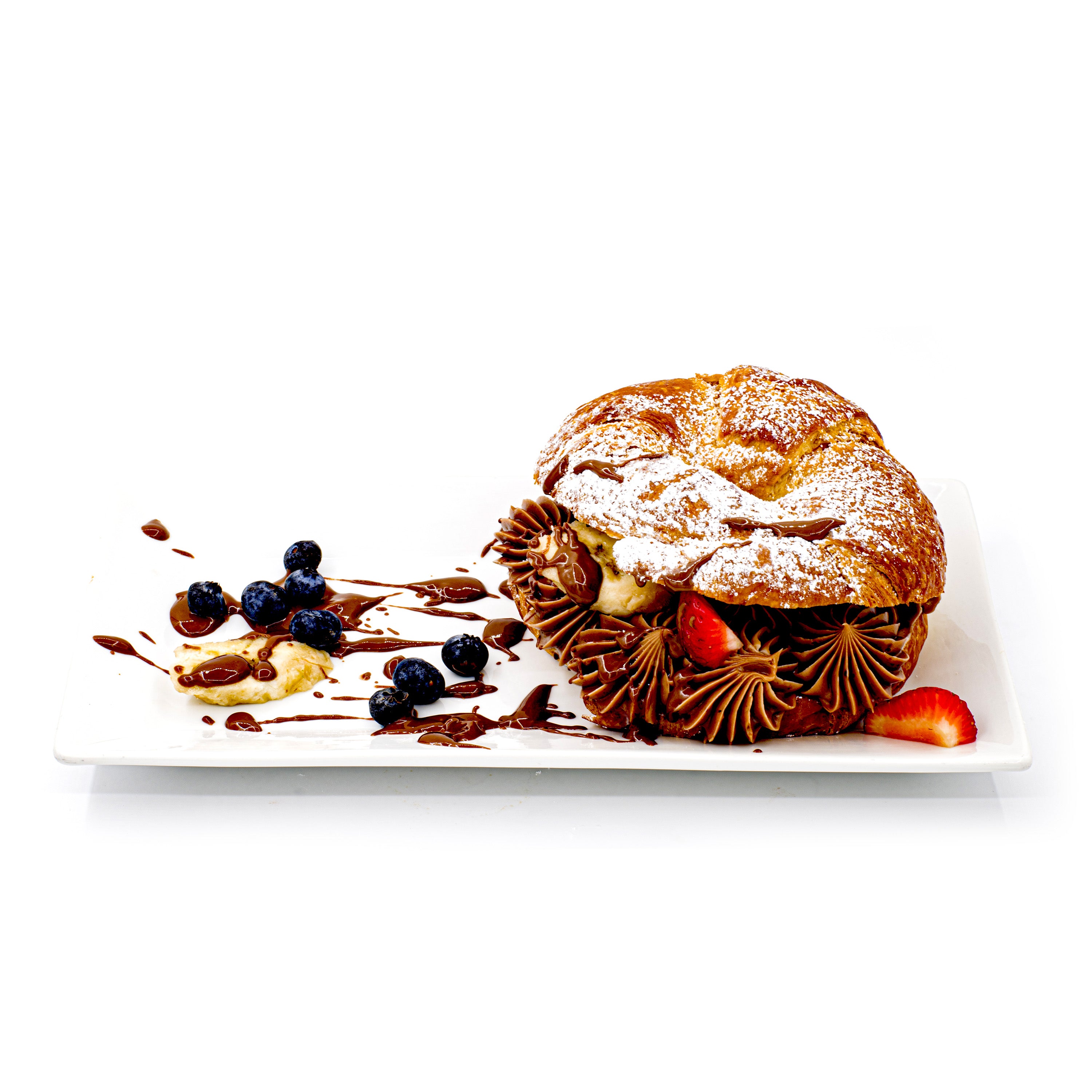 Chocolate cream-filled pastry with strawberries, blueberries, and banana on a white plate