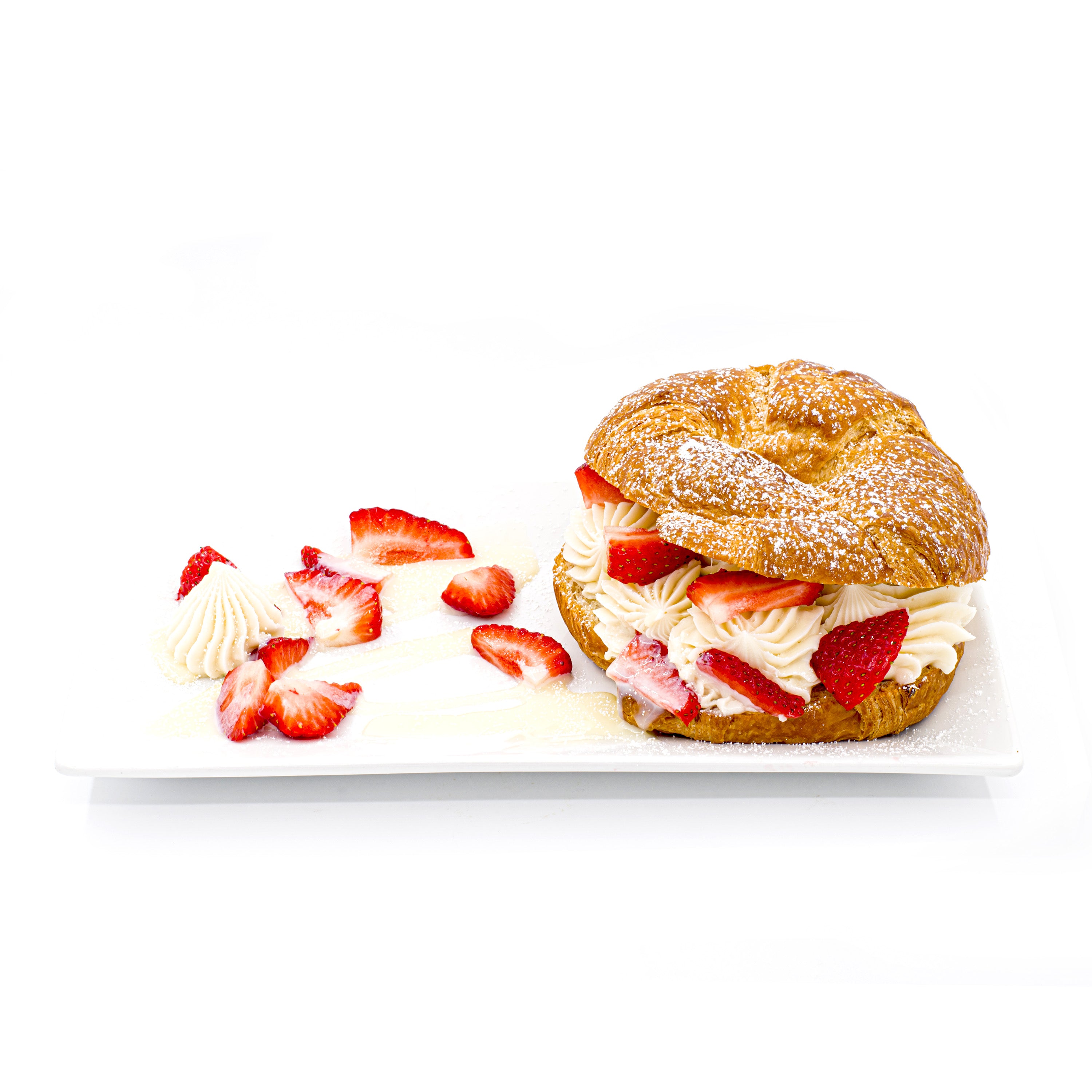 Croissant filled with whipped cream and fresh strawberries on a white plate, pastry dessert