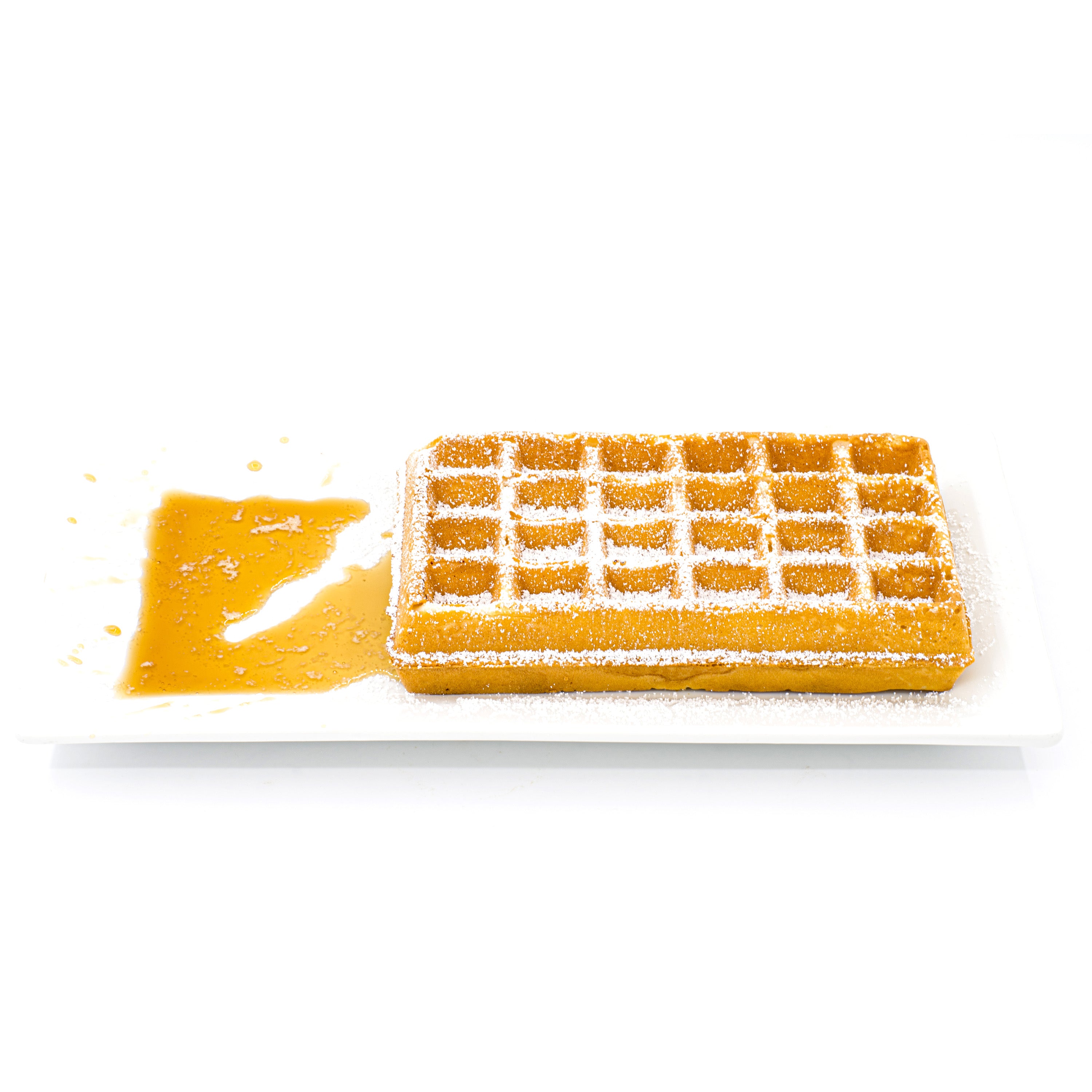 Golden Belgian waffle dusted with powdered sugar and syrup on a white rectangular plate