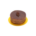 Chocolate mousse cake with glossy ganache and decorative chocolate swirl on a yellow base