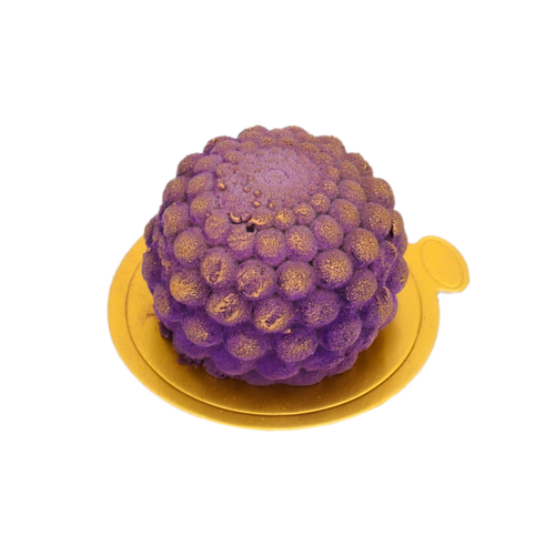 Purple blueberry mousse dessert with gold accents on a round gold tray