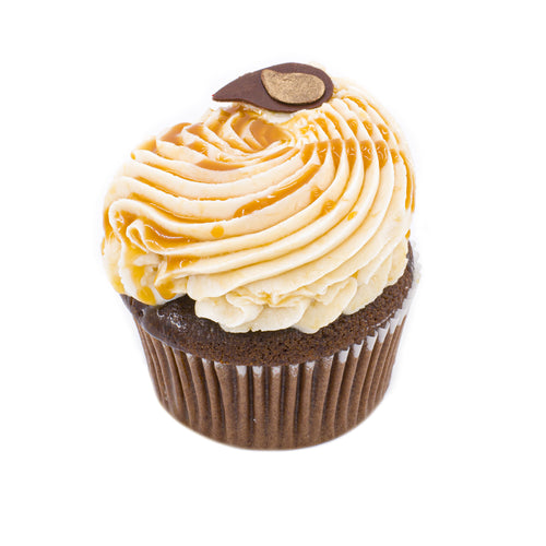 Chocolate cupcake with caramel frosting and decorative chocolate accent on white background
