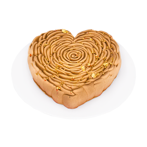 Heart-shaped mousse cake with gold decorative accents on a white plate