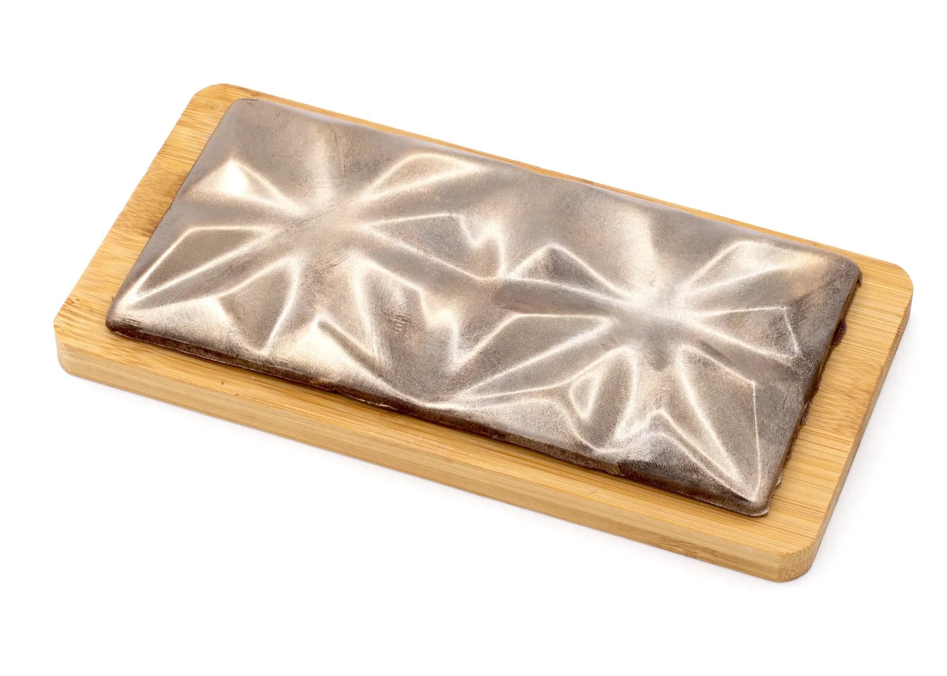 Gourmet chocolate bar with metallic finish and geometric pattern on a wooden board