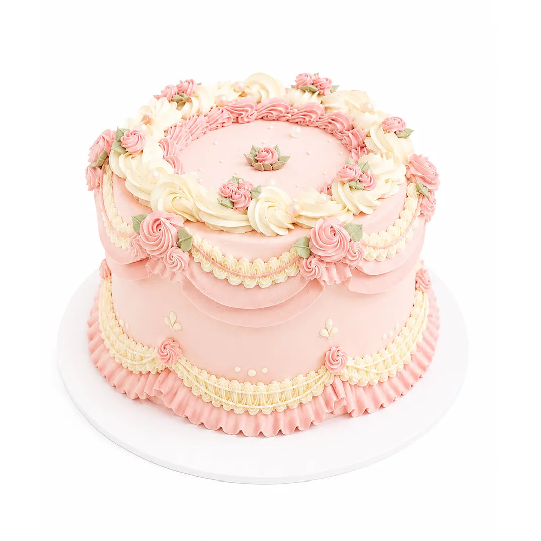 Happy Blossom Cake decorated with intricate pink and cream floral buttercream designs on a round celebration cake from a Beverly Hills bakery.