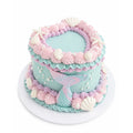 Round pastel blue and purple custom decorated Little Mermaid Cake featuring piped swirls, seashell and starfish decorations, and a mermaid tail accent on the side.