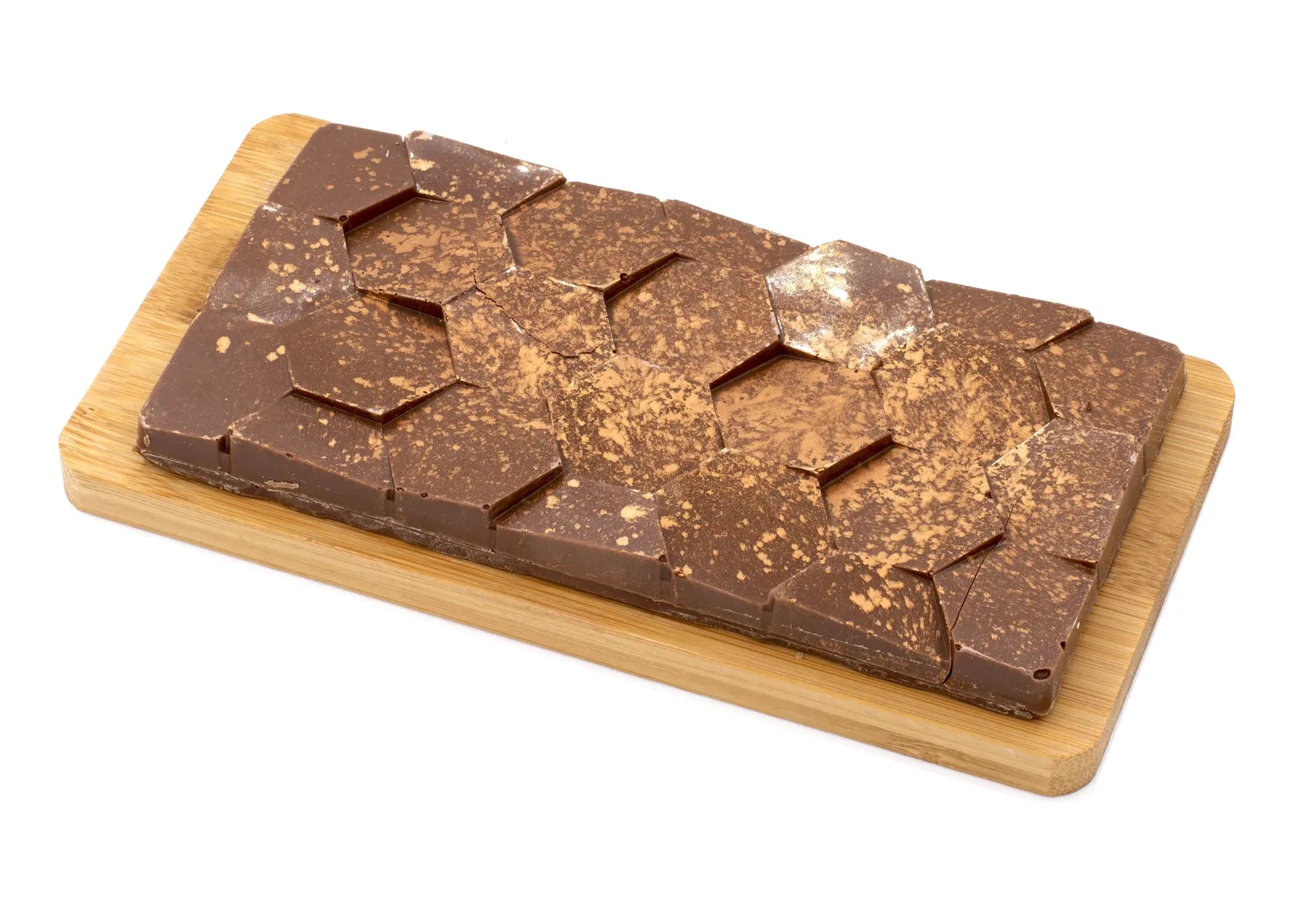 Milk chocolate bar with geometric pattern and dusting of espresso on wooden board