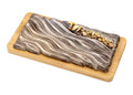 Milk chocolate bar with pistachio filling and chopped nuts on a wooden board