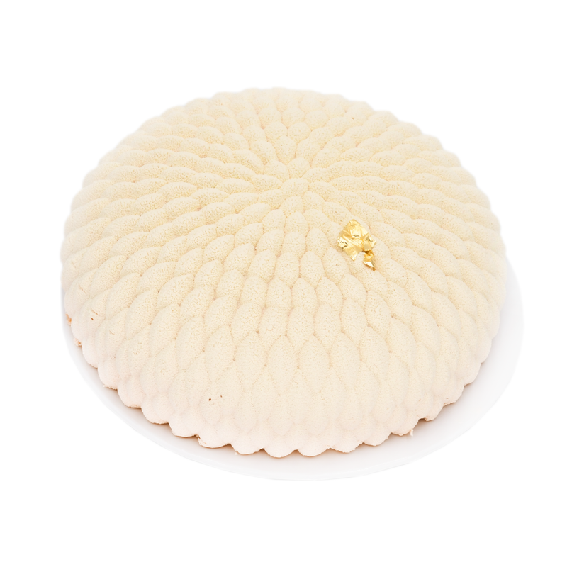 Elegant white mousse cake with textured pattern and gold leaf decoration on white plate