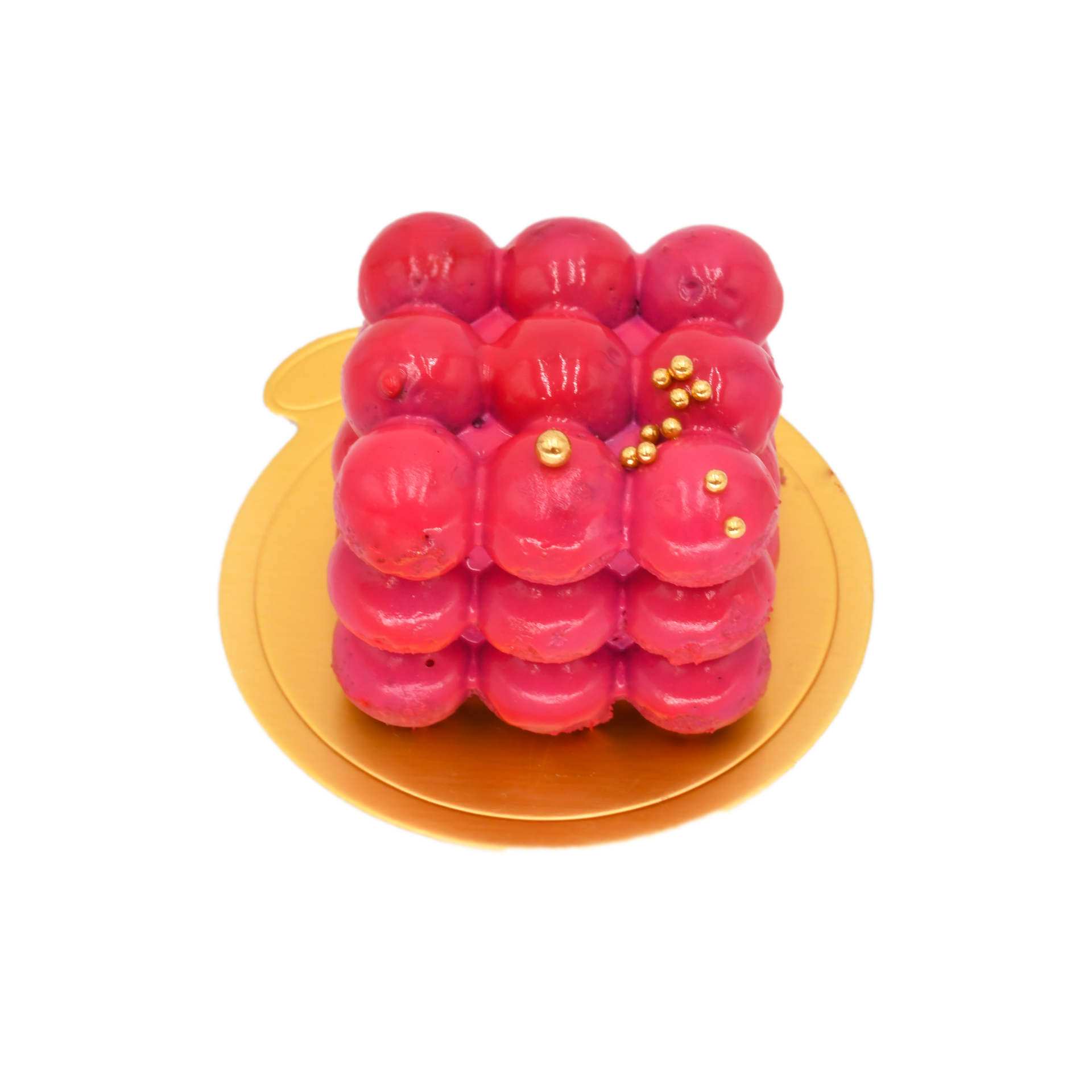Raspberry mousse dessert with glossy pink finish and gold pearls on a gold base