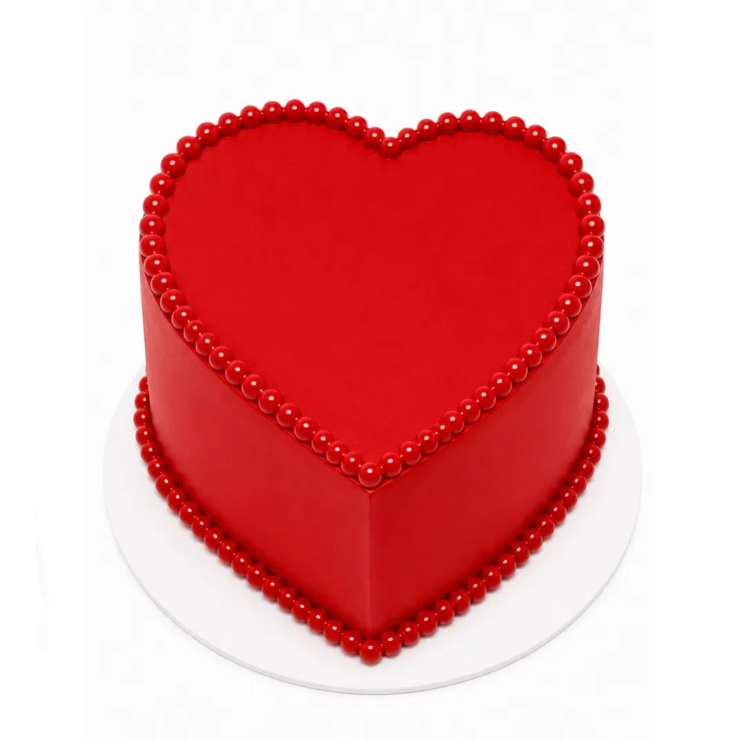Red Love Story Heart Cake with smooth red icing and decorative red bead border on top and base, presented on a white cake board for elegant celebrations.
