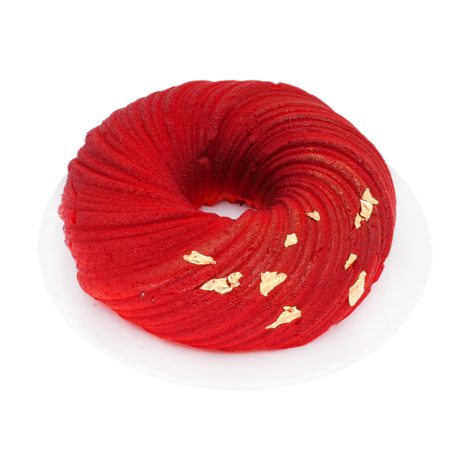 Red velvet mousse cake with swirl design and gold leaf on a white plate