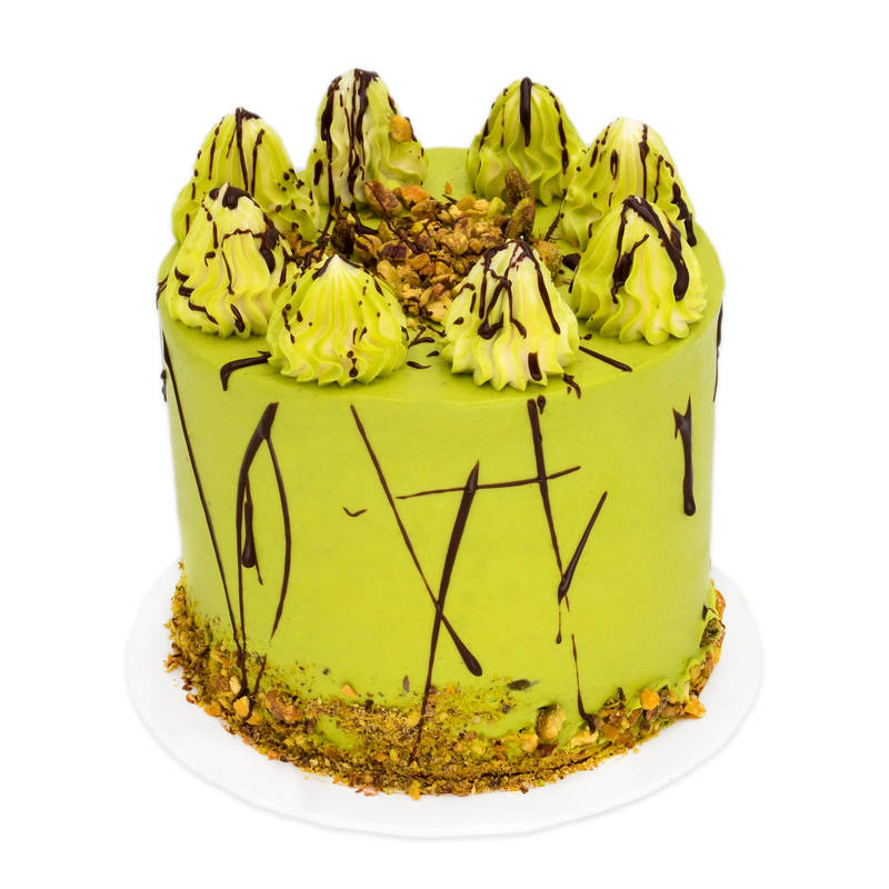 Pistachio gourmet cake with green frosting, chocolate drizzle, and chopped nuts on top