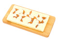 White chocolate bar with whole almonds on a wooden board, isolated on white background