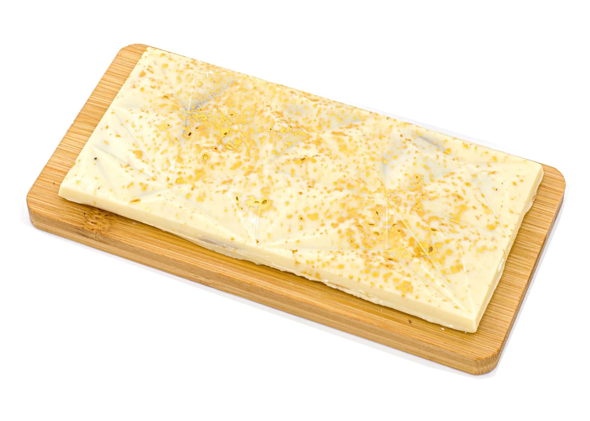 White chocolate bar with golden sprinkles on a wooden board
