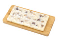 White chocolate bar with hazelnuts on a wooden board, gourmet chocolate dessert