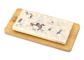 White chocolate bar with pecan pieces on a wooden board, gourmet chocolate dessert