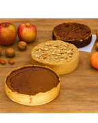 Assorted gourmet pies with nuts, apples, and pumpkin on wooden table, autumn dessert display