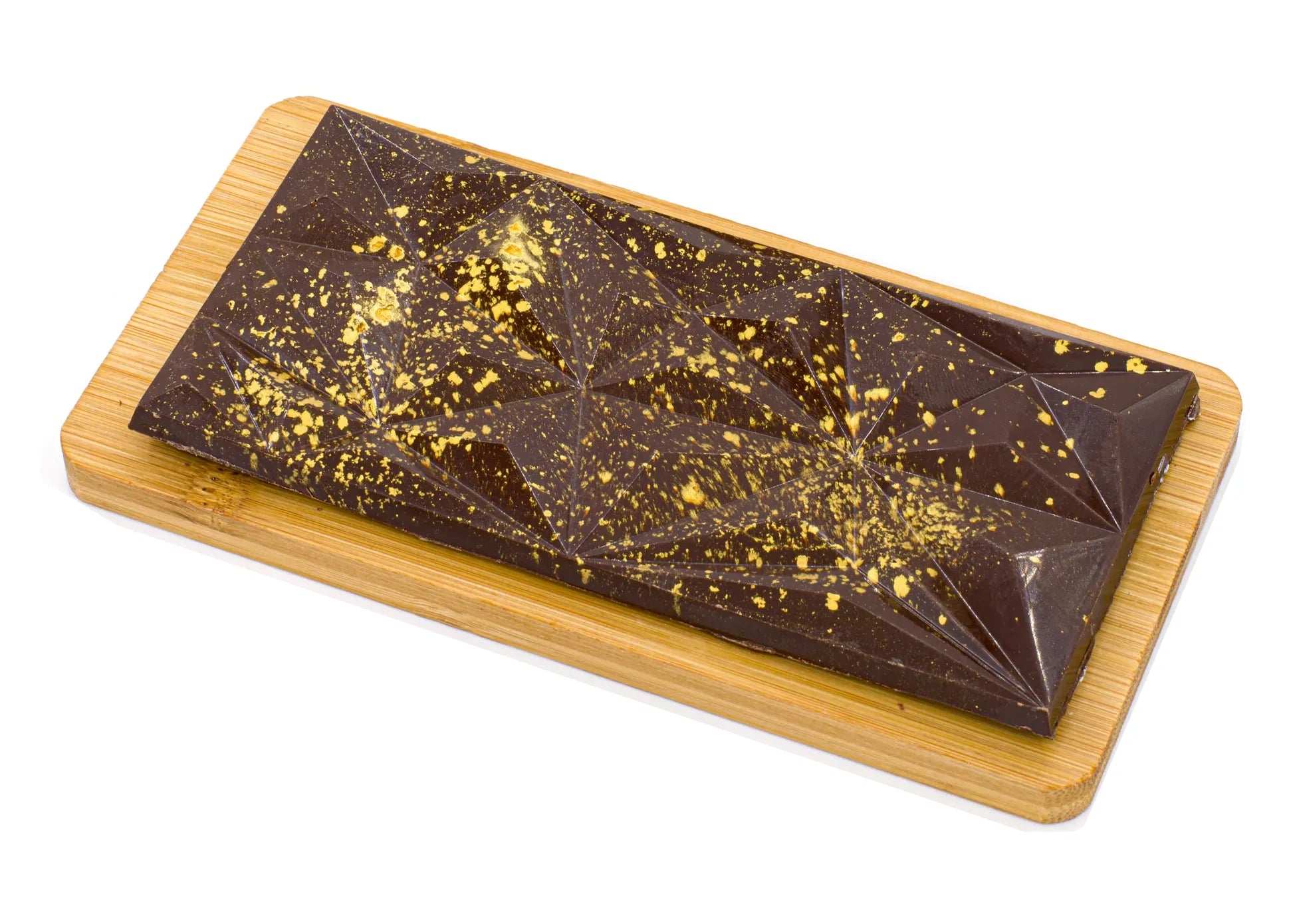 Geometric dark chocolate bar with gold splatter on a wooden board, gourmet dessert