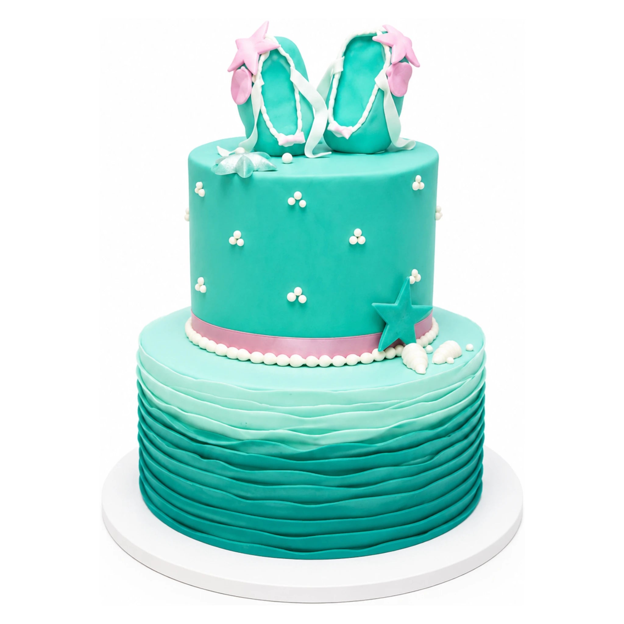 Two-tier teal cake with wave-textured bottom tier, decorated with small white pearl clusters, topped with teal fondant flip-flops adorned with pink stars and white straps, accented with a pink ribbon and starfish on the side.