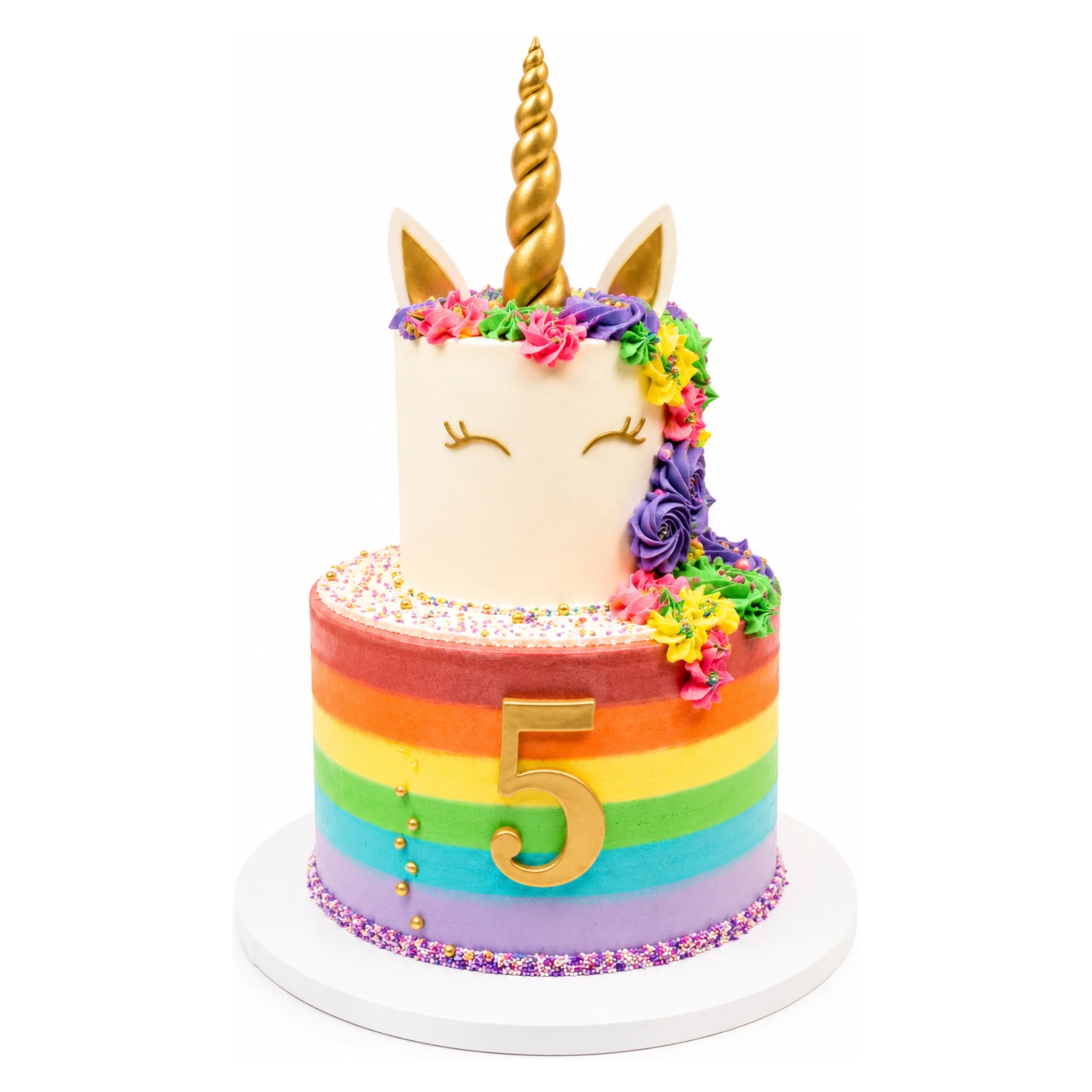 Rainbow Rosette Unicorn Cake with a gold horn, closed-eye face, colorful rosette mane, and a vibrant rainbow-striped base featuring a gold number 5 and sprinkles.