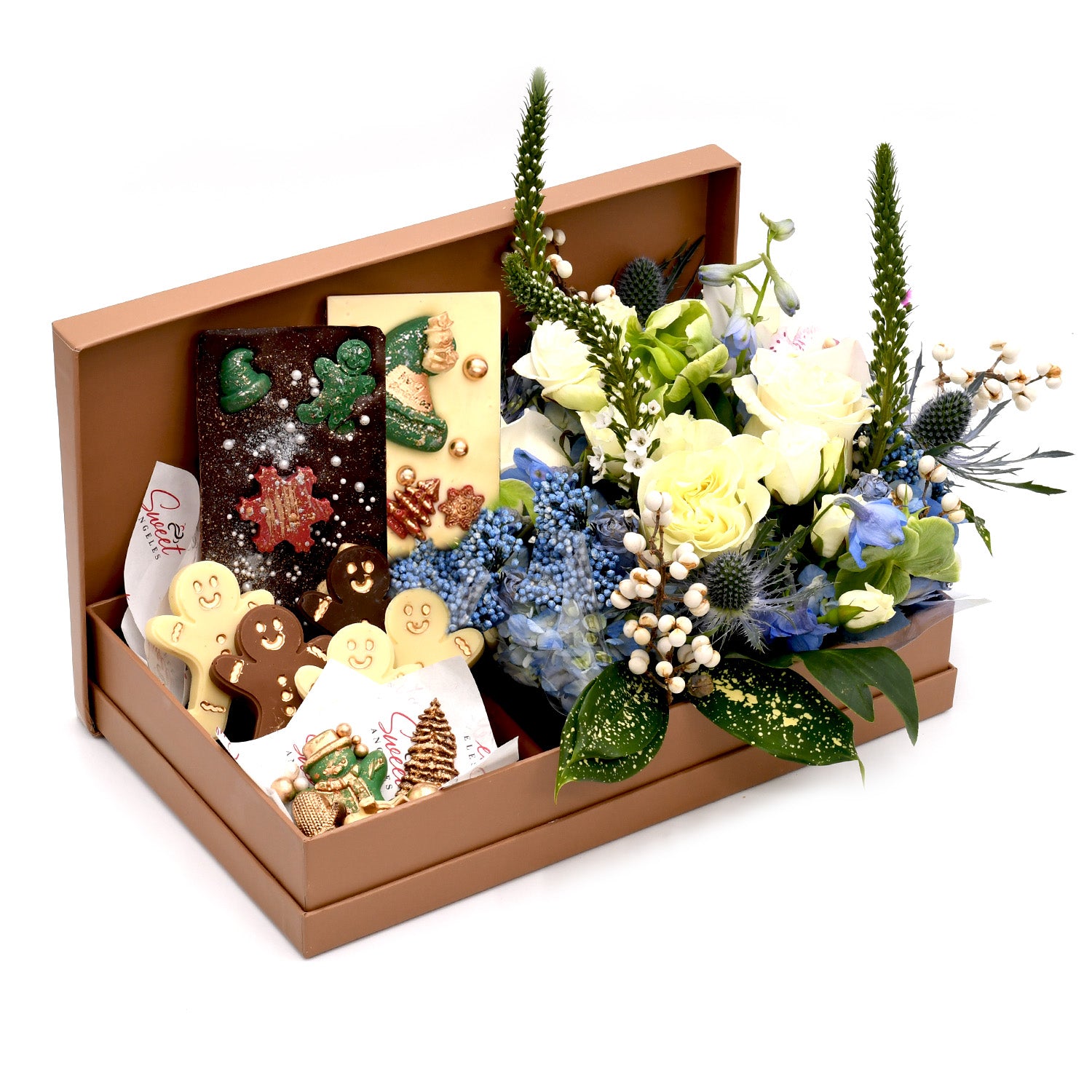 Gift box with assorted festive chocolates and cookies beside white and blue flower arrangement
