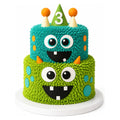 Two-tiered playful cake with textured green and blue frosting decorated as smiling monsters wearing party hats, featuring a green hat with number 3, called Double Monster Tier Cake.