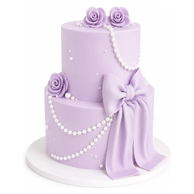 Lavender Pearl Bow Cake features two tiers covered in smooth lavender fondant, adorned with delicate pearl strands, elegant fondant roses, and a large matching bow for a sophisticated custom birthday cake.
