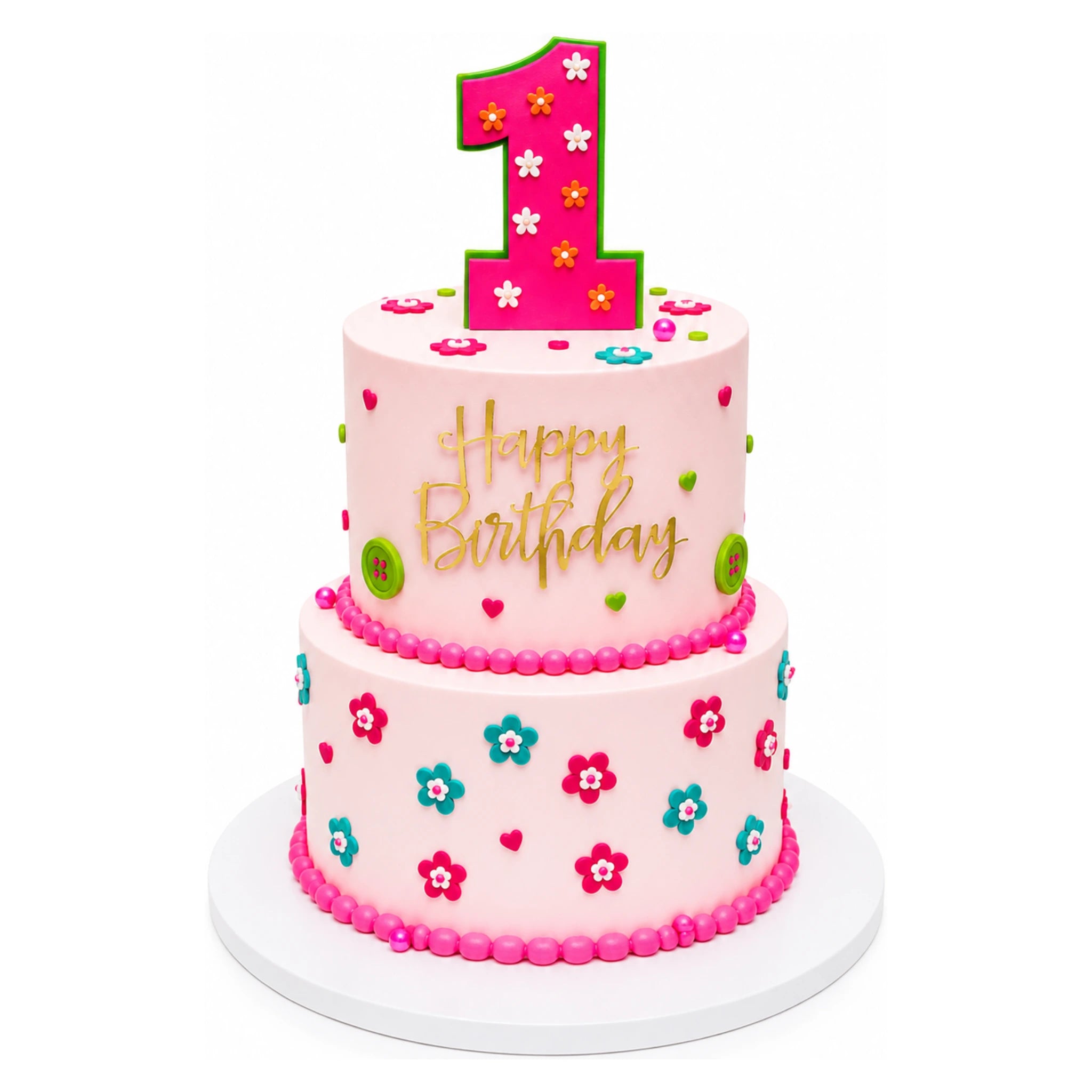 Two-tier pink birthday cake decorated with small colorful flowers and green buttons, topped with a large pink number one and gold "Happy Birthday" lettering on a white base.