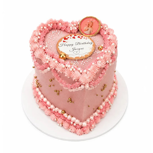 Birthday Queen Heart Cake featuring pink heart-shaped design with piped frosting, white and gold edible pearls, and a custom edible photo topper celebrating a birthday.