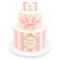 Pink Stripe Baby Booties Cake with two tiers decorated in pink and white stripes, a pink bow, and topped with edible baby booties, perfect for a baby girl celebration.
