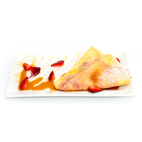 Strawberry crepes with caramel sauce and powdered sugar on a white plate