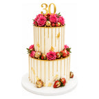 Elegant two-tier Gold Drip Rose & Strawberry Cake decorated with vibrant pink roses, gold accents, fresh strawberries, and a gold "30" topper perfect for luxury celebrations.