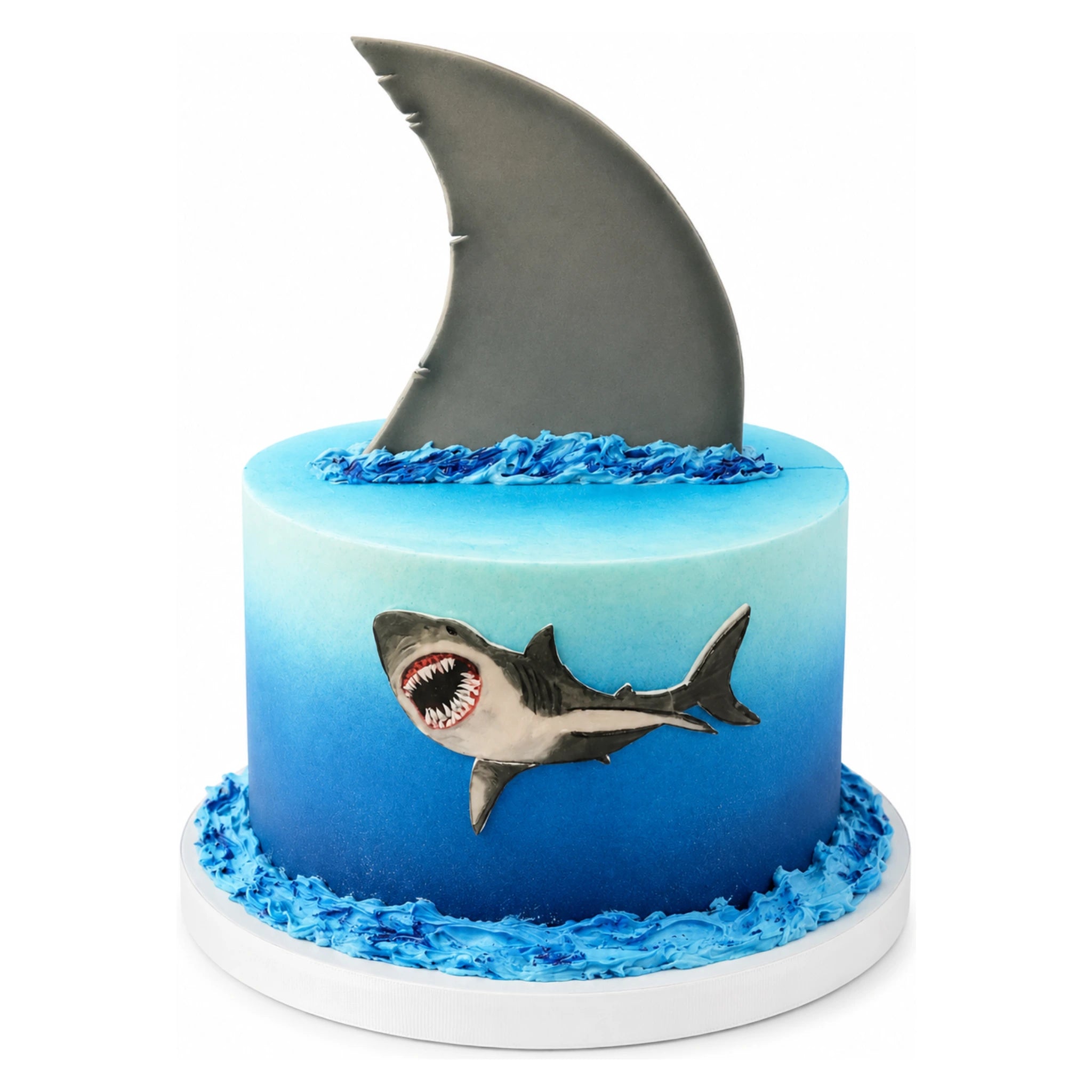 Great White Shark Cake featuring an ocean-blue gradient design with a detailed shark illustration and a large gray shark fin topper surrounded by textured blue waves.