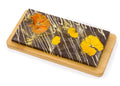 Gourmet dark chocolate bar with edible dried flowers and gold dust on wooden board