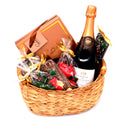 Gift basket with chocolate treats, a box of sweets, and a bottle of sparkling wine