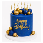 Navy Gold Birthday Cake featuring navy blue smooth icing with elegant gold speckles, topped with gold and navy spheres, a gold macaron, and gold "Happy Birthday" script decoration.