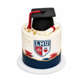 Elegant LMU Graduation Cake featuring a black fondant graduation cap with red tassel, a rolled diploma, gold accents, and a bold blue and white design, symbolizing luxury custom cakes.