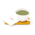 Cup of green tea on a wooden tray with a napkin, isolated on white background